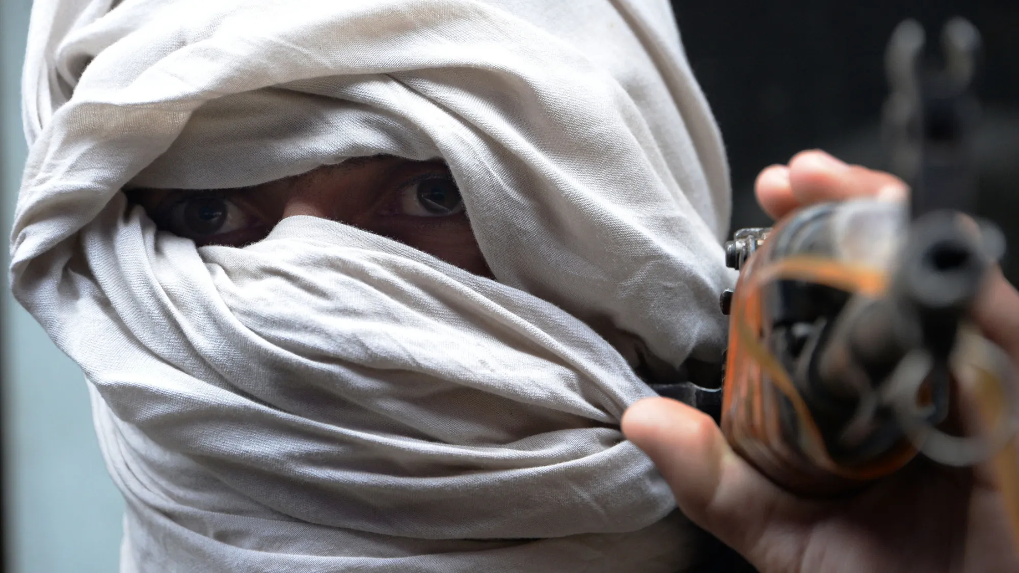 An Afghan former Taliban fighter carries his weapon before handing it over as part of a government peace and reconciliation process at a ceremony in Jalalabad.
