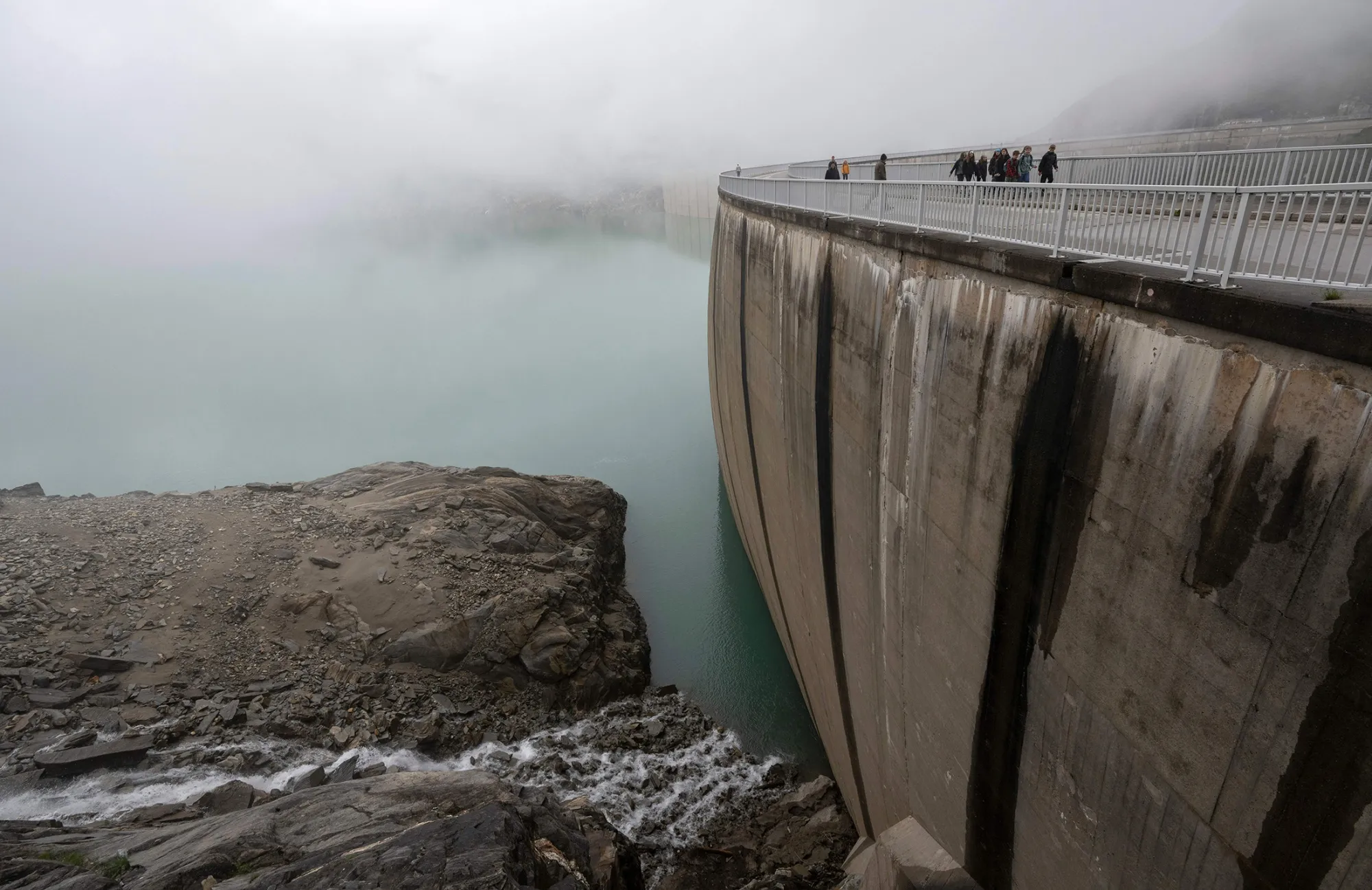 Tourists walk on the walls of the Mooserboden dam near Kaprun, in the Austrian Alps.