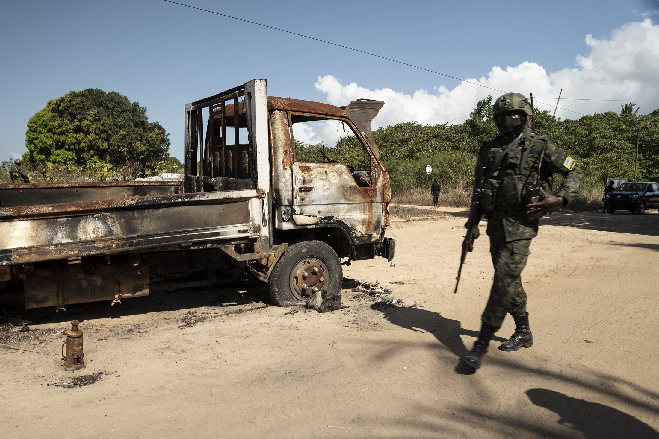 A Rwandan soldier walks in front of a burned truck near Palma, Cabo Delgado, Mozambique on September 22, 2021. - Since July 2021 a contingent of a thousand Rwandan soldiers and policemen is deployed to Mozambique to fight insurgents that were terrorising populations. The Rwanda Defence Forces (RDF) declared few victories among which the liberation of Mocimboia Da Praia which was occupied by jihadist for almost a year. (Photo by Simon WOHLFAHRT / AFP) (Photo by SIMON WOHLFAHRT/AFP via Getty Images) Photographer: SIMON WOHLFAHRT/AFP
