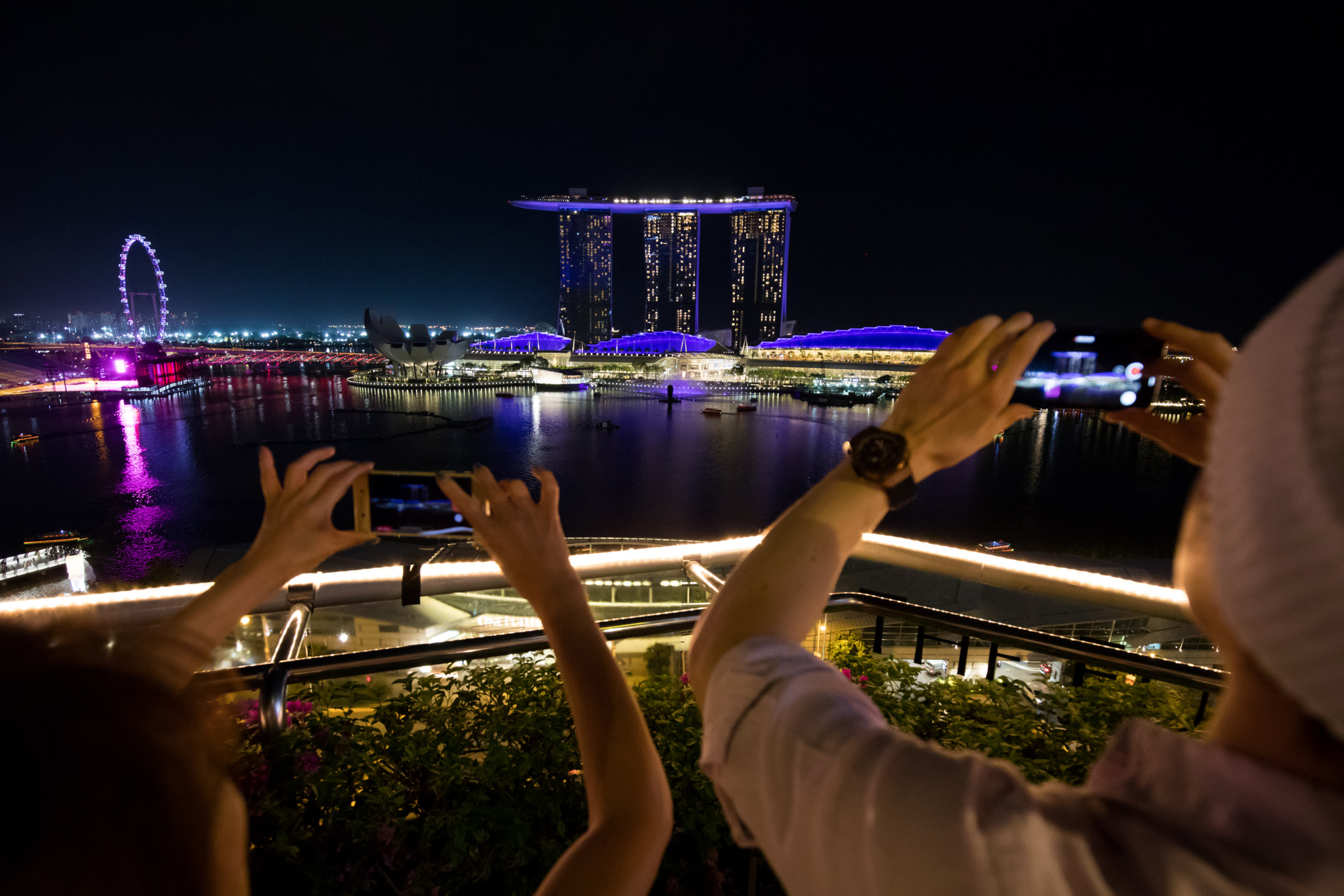 People take photographs of the skyline&nbsp;in Singapore.