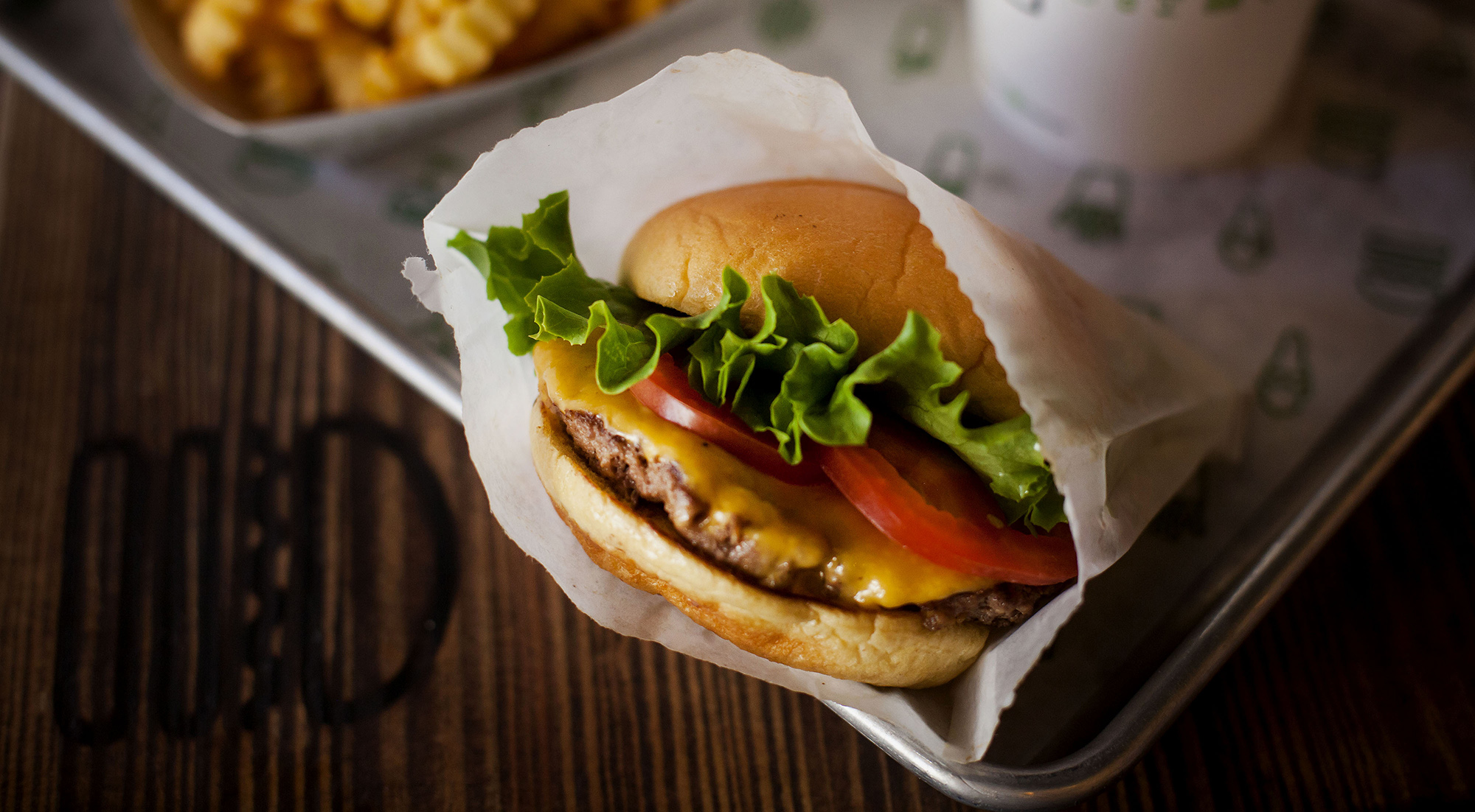 A burger, fries, and beverage are arranged for a photograph at a Shake Shack restaurant in New York.