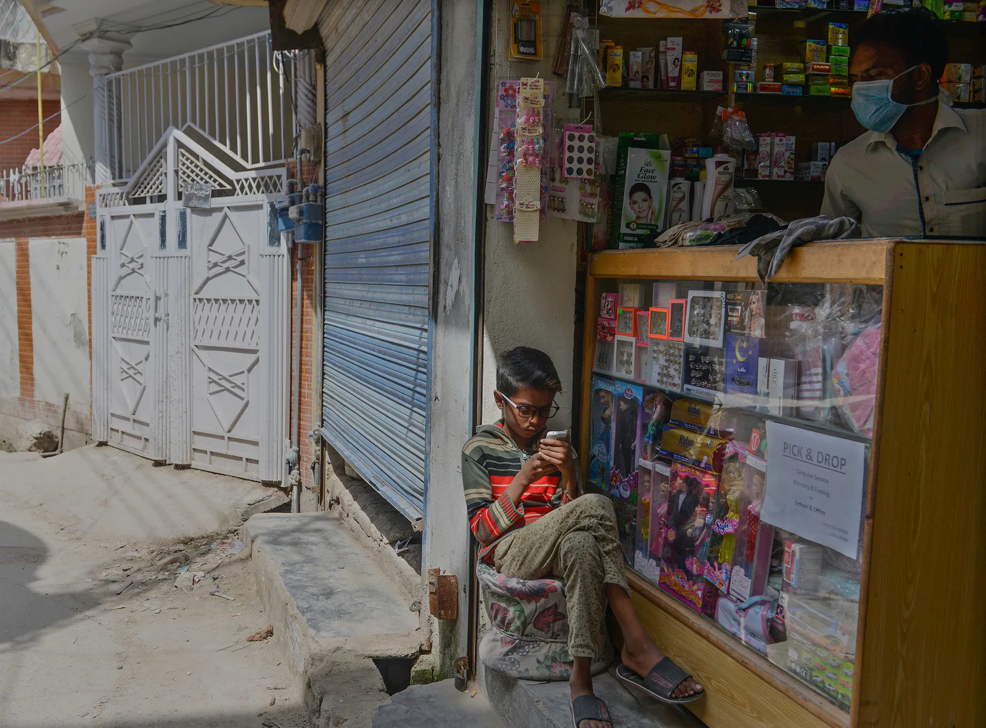 A boy uses a phone outside a shop on the outskirts of Islamabad on April 7.