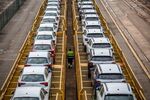 A worker inspects newly manufactured automobiles on rail wagons at Barcelona commercial port in Barcelona, Spain.
