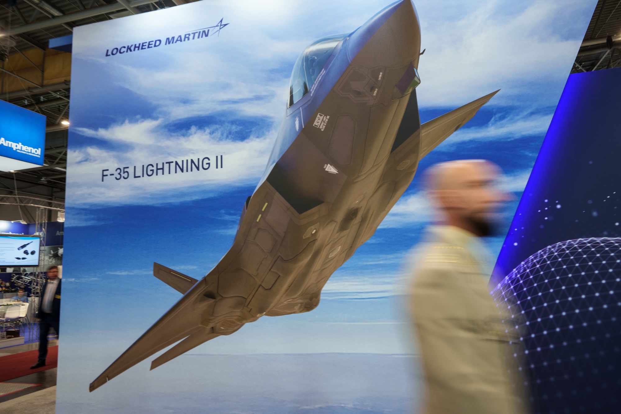 An F-35 Lighting II fighter jet poster at the Lockheed Martin Corp. stand at the International Defence and Security Technologies Fair (IDET) in Brno, Czech Republic, on Wednesday, May 28, 2025. The European Union’s 27 member states gave initial approval to a €150 billion defense fund that will distribute money to countries looking to invest in security capabilities according to people familiar with the matter.