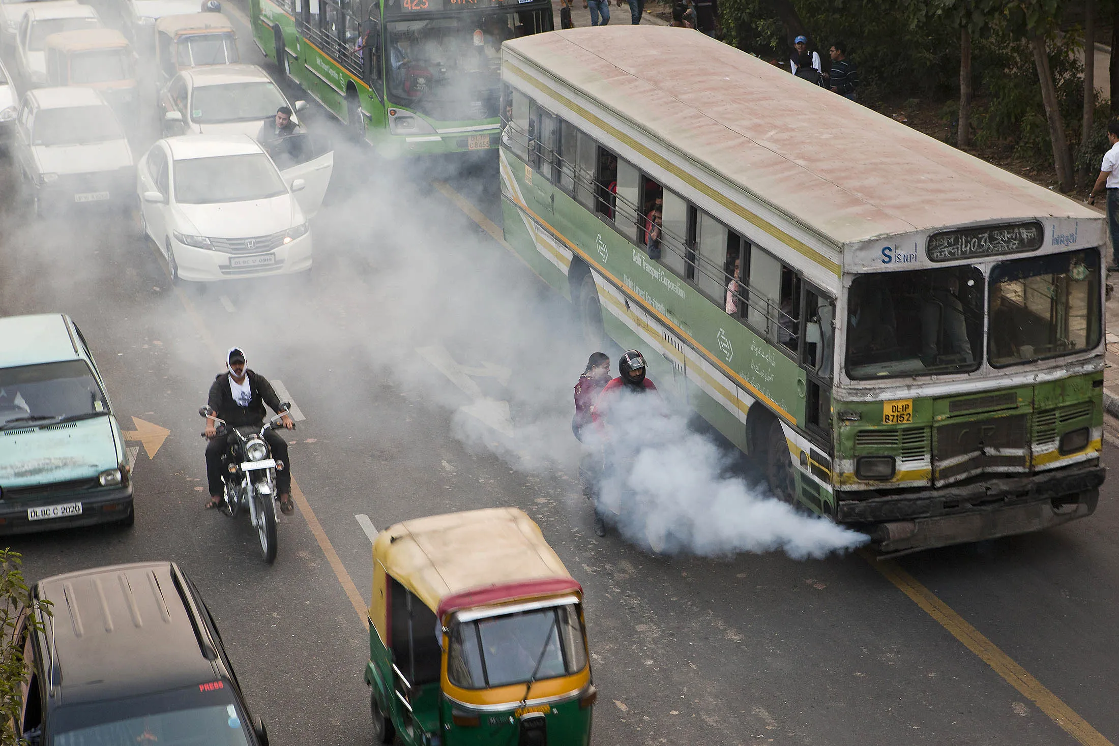 Smoke comes out of a public bus waiting at a traffic light in New Delhi, India, on Saturday, Nov. 26, 2011. Morgan Stanley reduced its growth estimate for India to 7 percent from 7.2 percent earlier for the year ending March 31, according to an e-mailed statement today.
