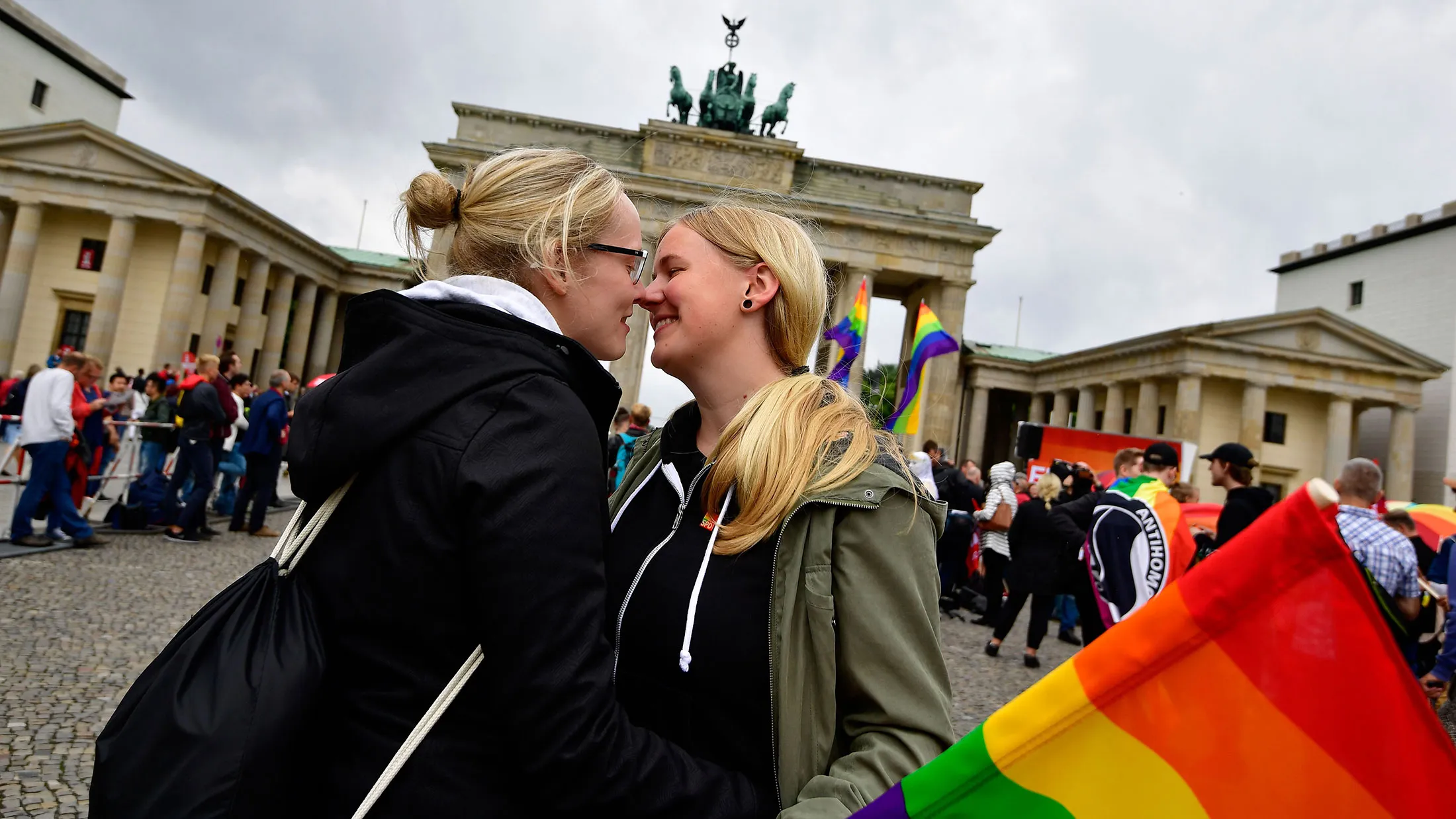 Women kiss at a rally in front of the Brandenburg Gate in Berlin on June 30, 2017.
