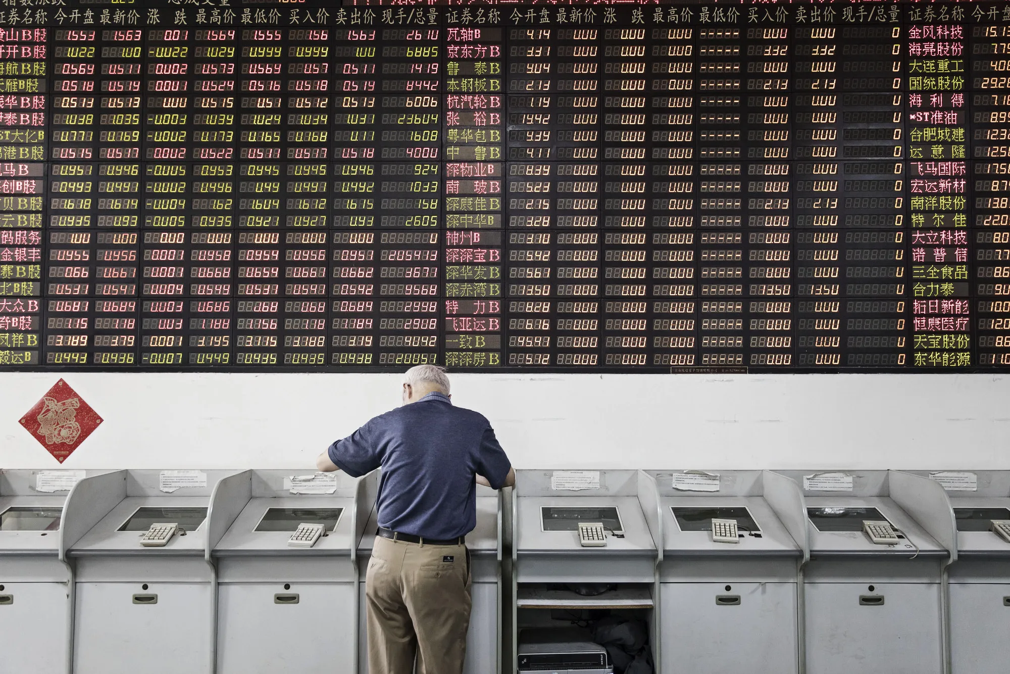 An investor stands at a trading terminal at a securities brokerage in Shanghai.