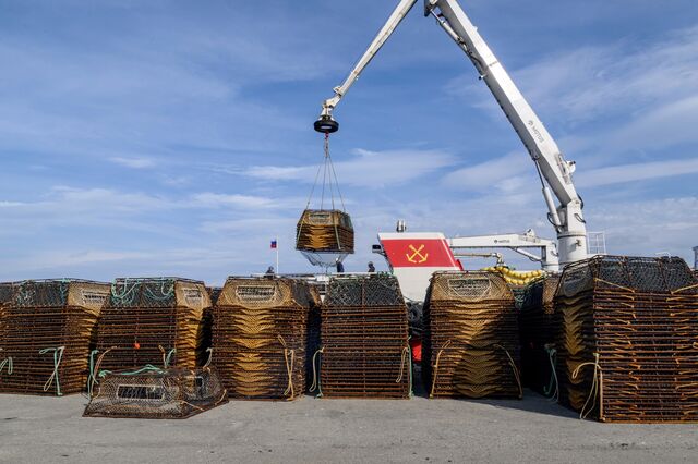 A Russian fishing boat carefully loads traps from the jetty.