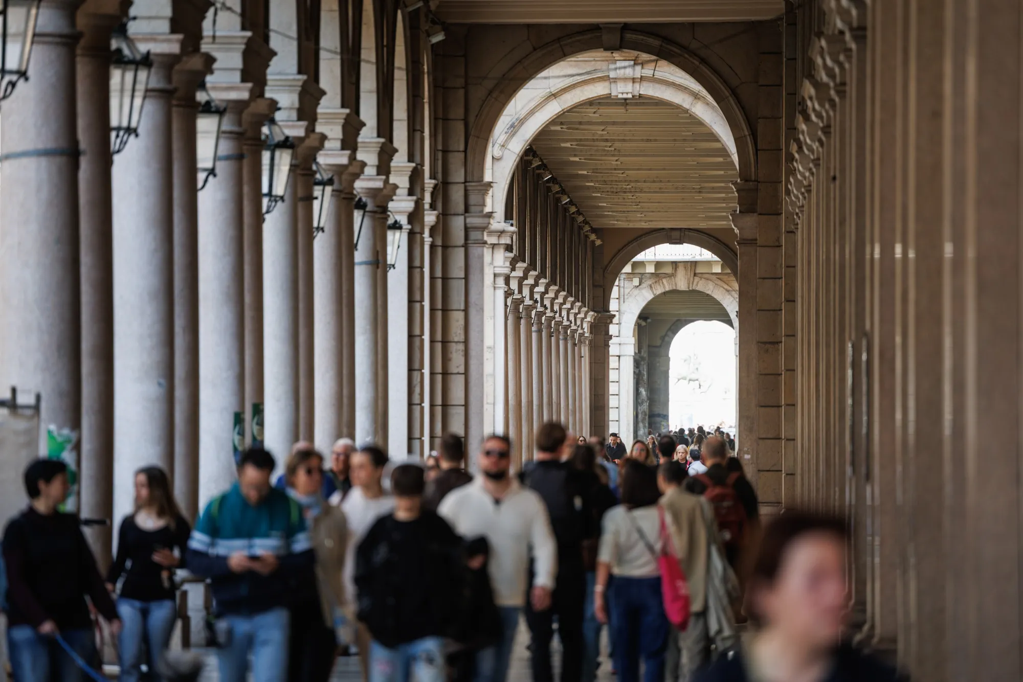 Pedestrians pass stores in a shopping street in Turin, Italy.