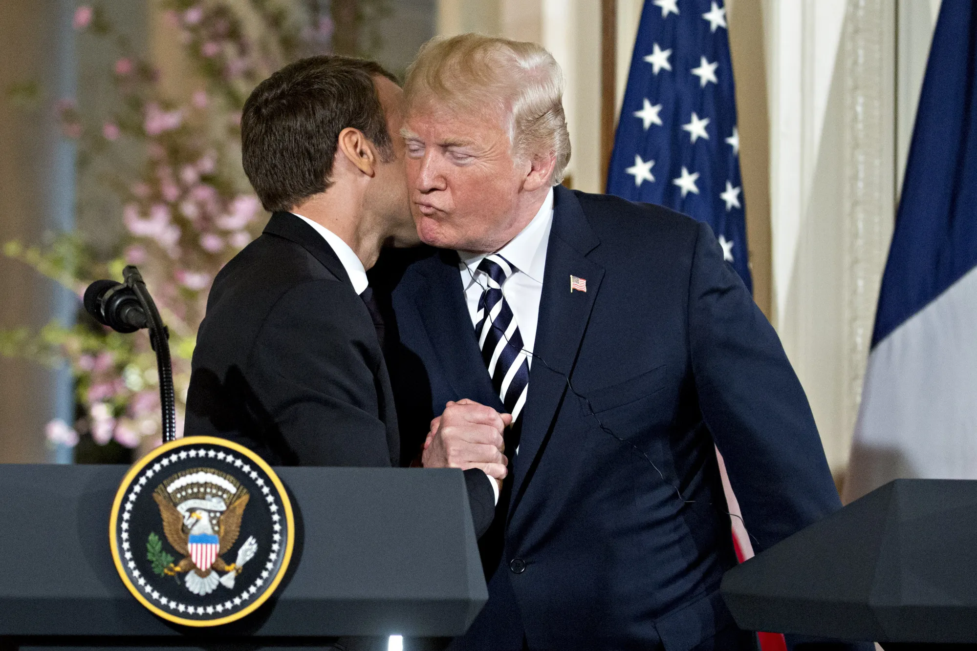 Donald Trump, embraces Emmanuel Macron in April