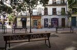 A pedestrian walks a dog through a deserted Plaza Matute past shuttered stores in Madrid, Spain, on Monday, April 13, 2020.
