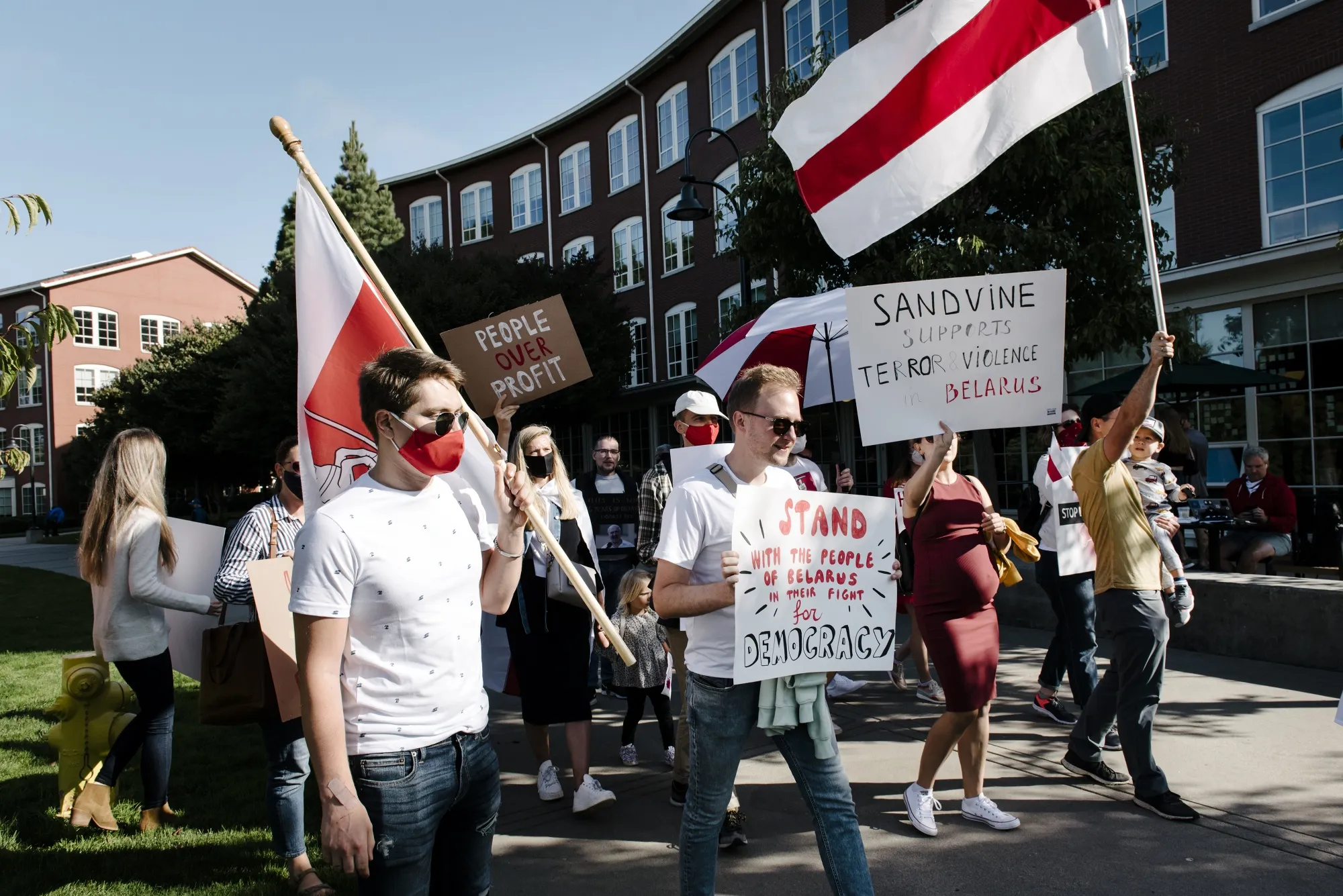 Demonstrators hold signs and wave Belarus flags during a protest outside Francisco Partners headquarters in San Francisco, California, on&nbsp;Sept. 18.