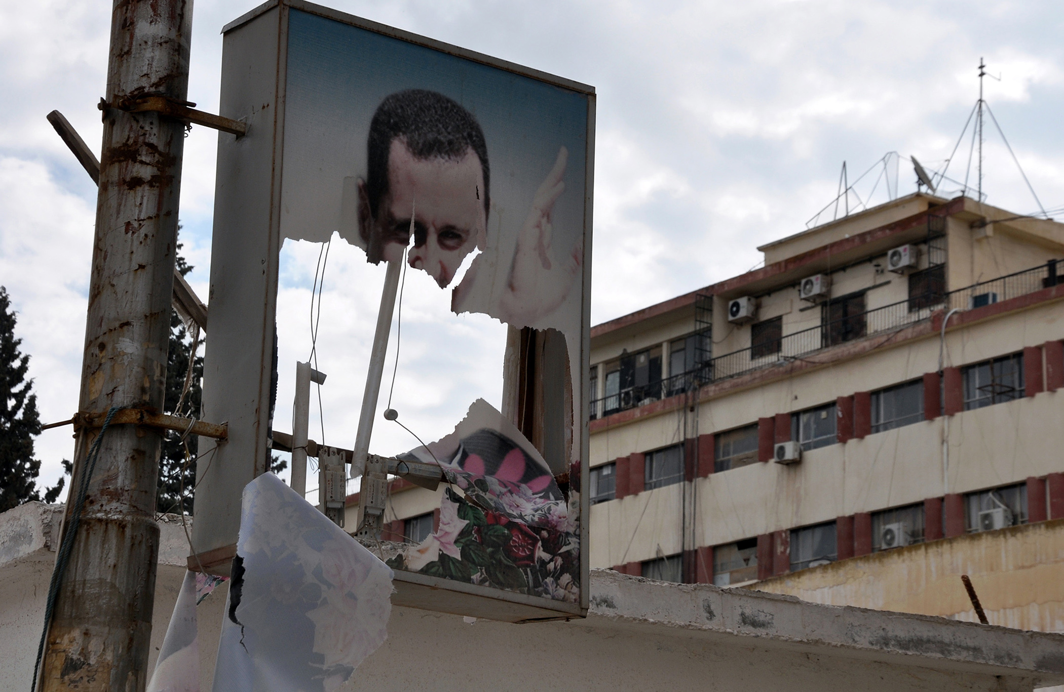 A ripped picture of Syrian President Bashar al-Assad hangs in the northern Syrian city of Raqqa following days of fierce fighting on March 5, 2013.
