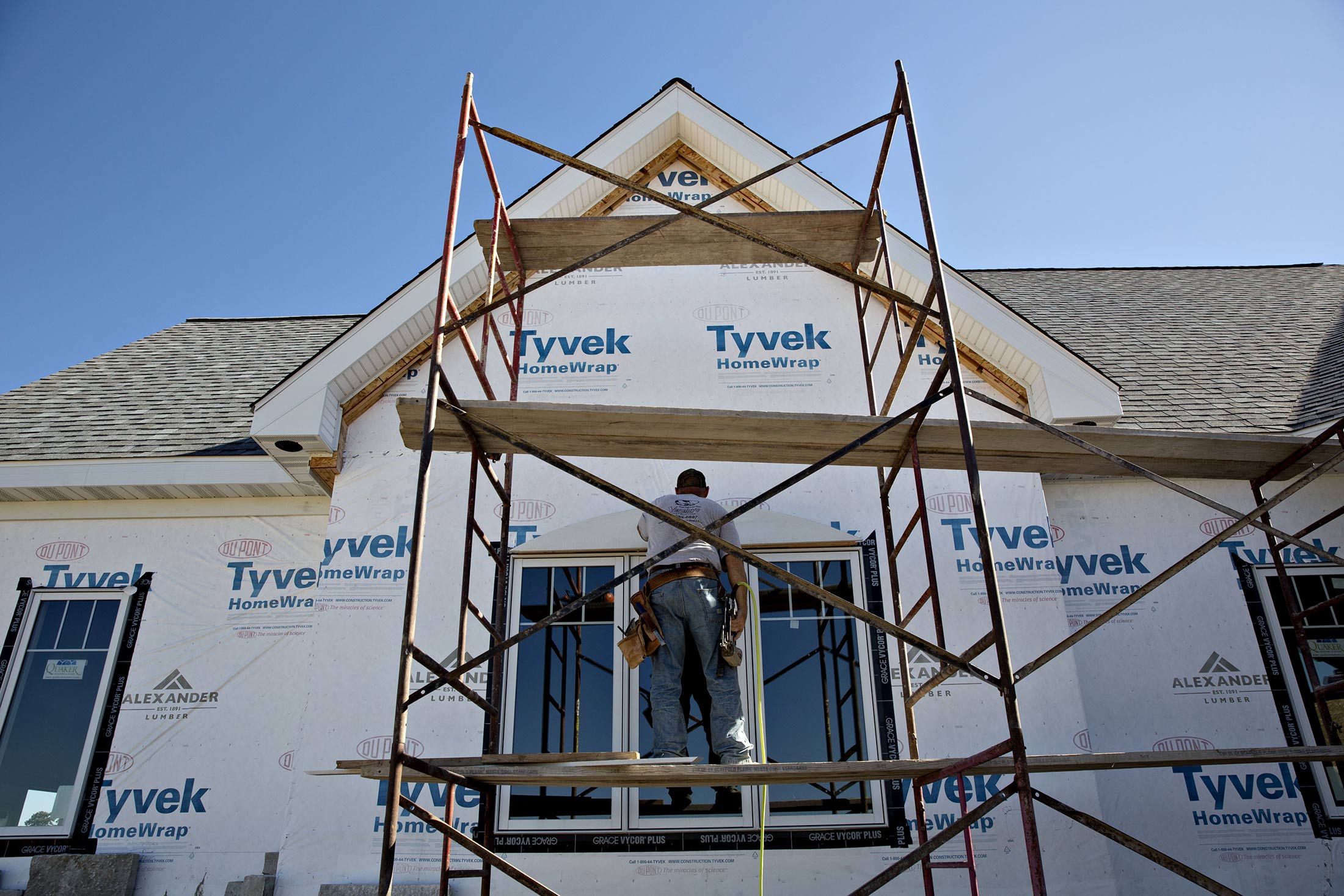 A contractor installs trim on a home under construction in Sycamore, Illinois.
