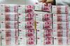 An employee arranges bundles of Chinese one-hundred yuan banknotes at the Counterfeit Notes Response Center of KEB Hana Bank in Seoul, South Korea, on Monday, Dec. 21, 2015. The offshore yuan climbed the most in a week on optimism that China's leaders are focusing on boosting growth in the world's second-largest economy.