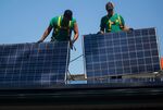 SolarCity Corp. employees install solar panels.
