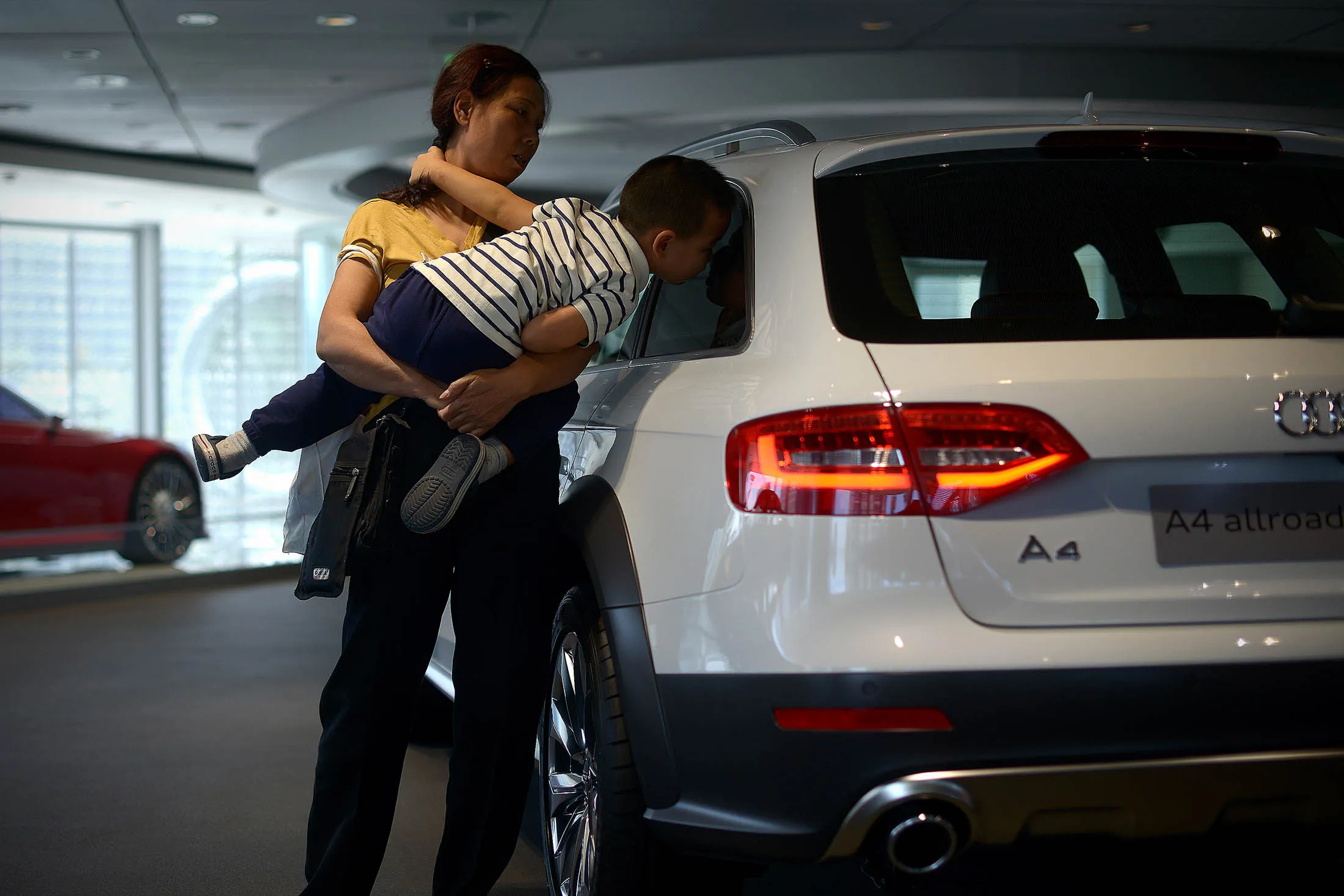 A child looks into a car window at a car dealership in Beijing. Wholesale deliveries of passenger and commercial vehicles climbed 4.7 percent to 24.6 million units last year, the smallest rate of increase since 2012, according to the state-backed China Association of Automobile Manufacturers.
