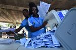 Election workers empty a box containing ballot papers at a polling station in Freetown on March 7.