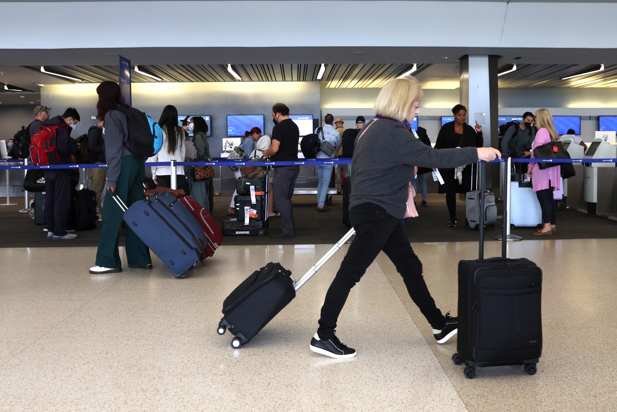 Travelers with their luggage at San Francisco International Airport.