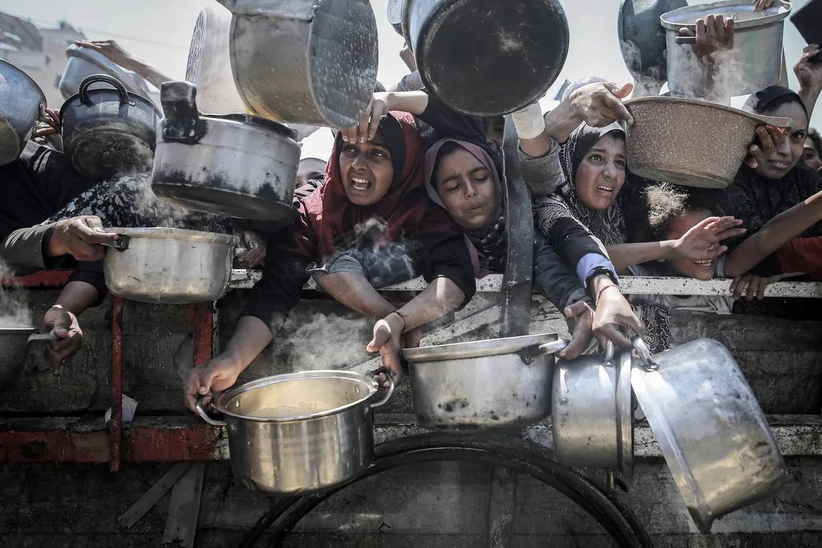 Palestinians collect food from a charity kitchen in Gaza City on Aug. 4.