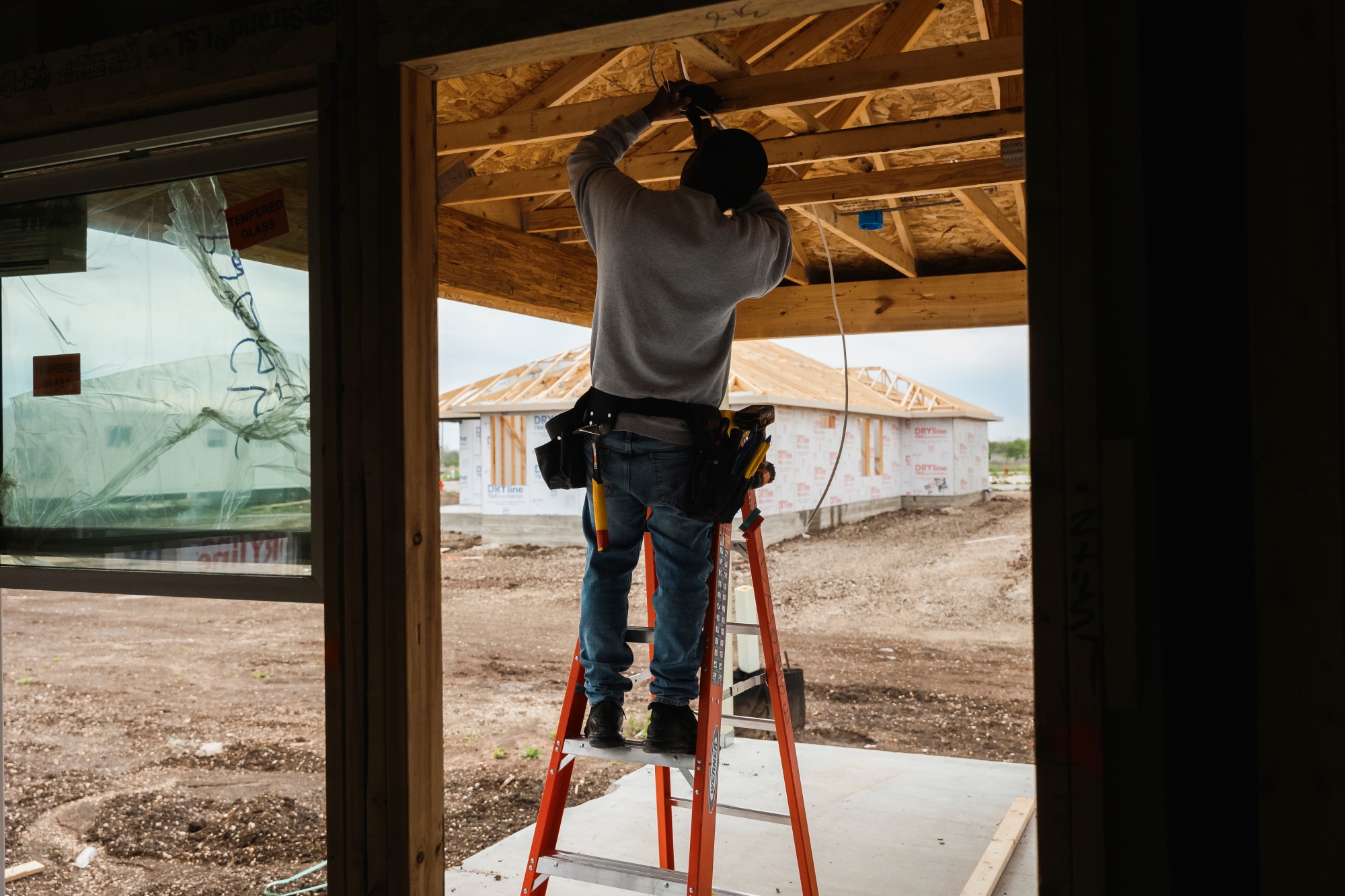 A worker installs electrical wiring in a home under construction in Kyle, Texas.