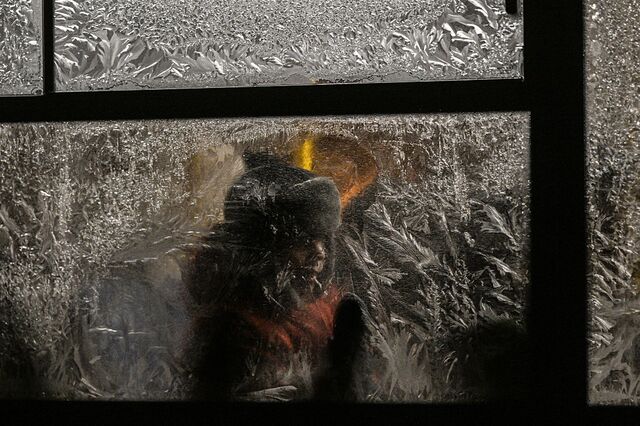 A young person rides a bus during a winter evening in Kyiv. The city is experiencing its coldest winter in decades and Russian attacks have left residents without reliable heating and power.