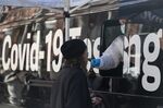 A healthcare worker administers a Covid-19 test at a mobile testing site in the Washington Square Park neighborhood of New York, U.S., on Monday, Dec. 20, 2021.