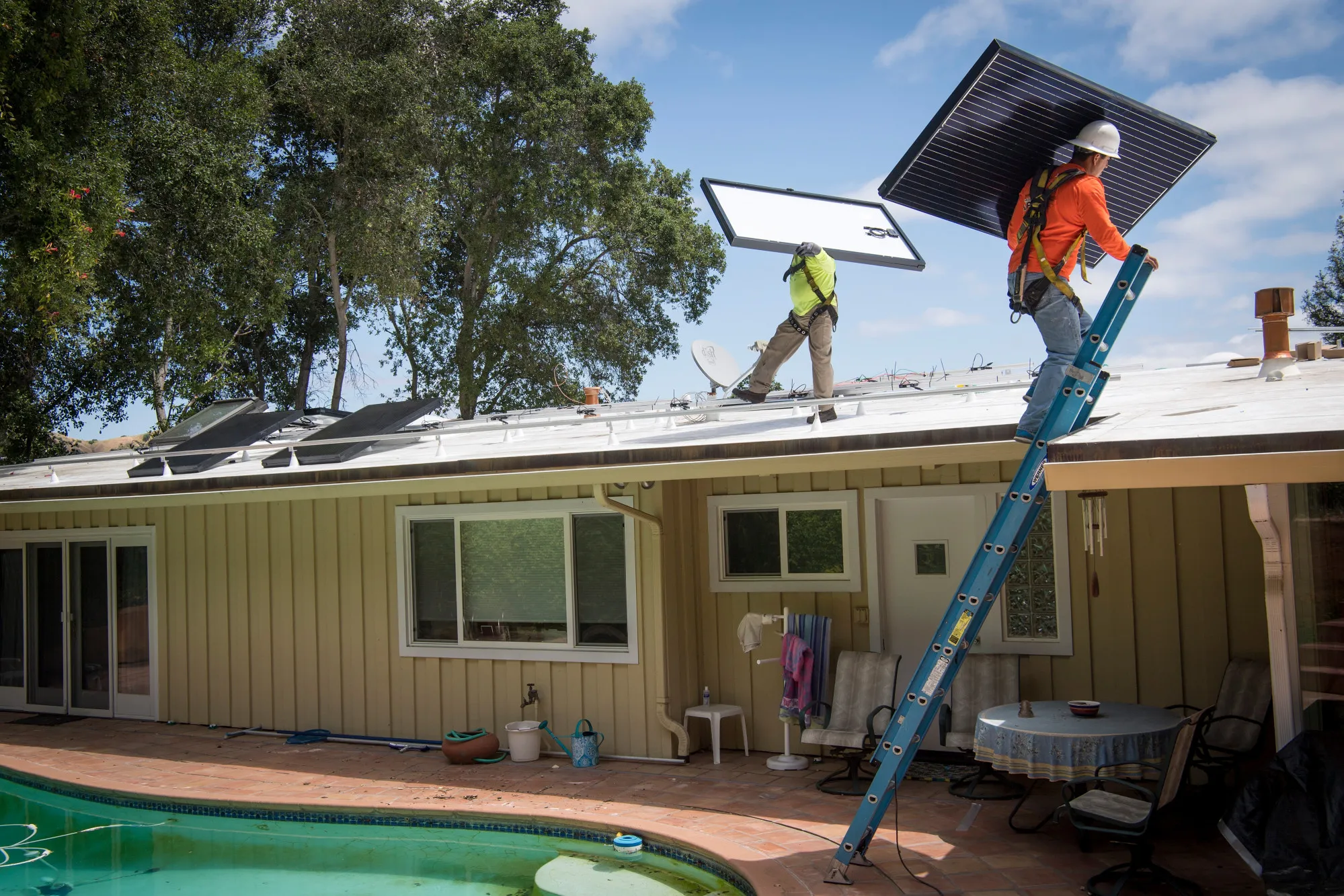 Workers install solar panels on the&nbsp;roof of a home in Lafayette, California.