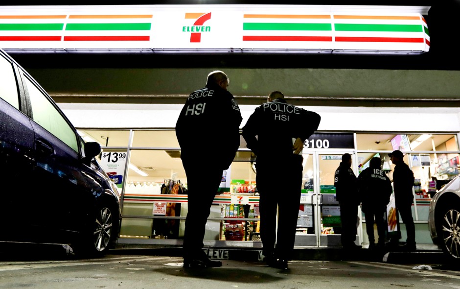 U.S. Immigration and Customs Enforcement agents serve an employment audit notice at a 7-Eleven in Los Angeles.