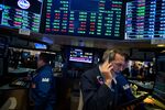 A television screen displays news about the Dow Jones Industrial Average reaching 26,000 while traders work on the floor of the New York Stock Exchange (NYSE) in New York, U.S., on Tuesday, Jan. 16, 2018.