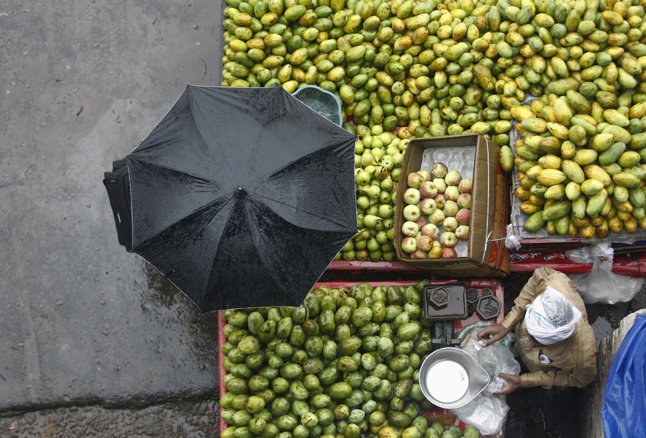 A vendor sells fruits during a heavy monsoon rain shower in New Delhi.