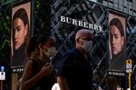 Pedestrians wearing protective masks walk past a Burberry Group Plc store on Canton Road in Hong Kong.