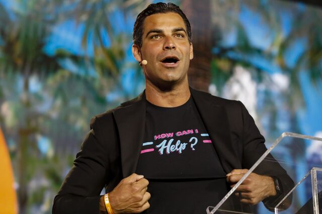 Francis Suarez wears a “how can I help?” t-shirt while speaking on stage during a Bitcoin conference. 