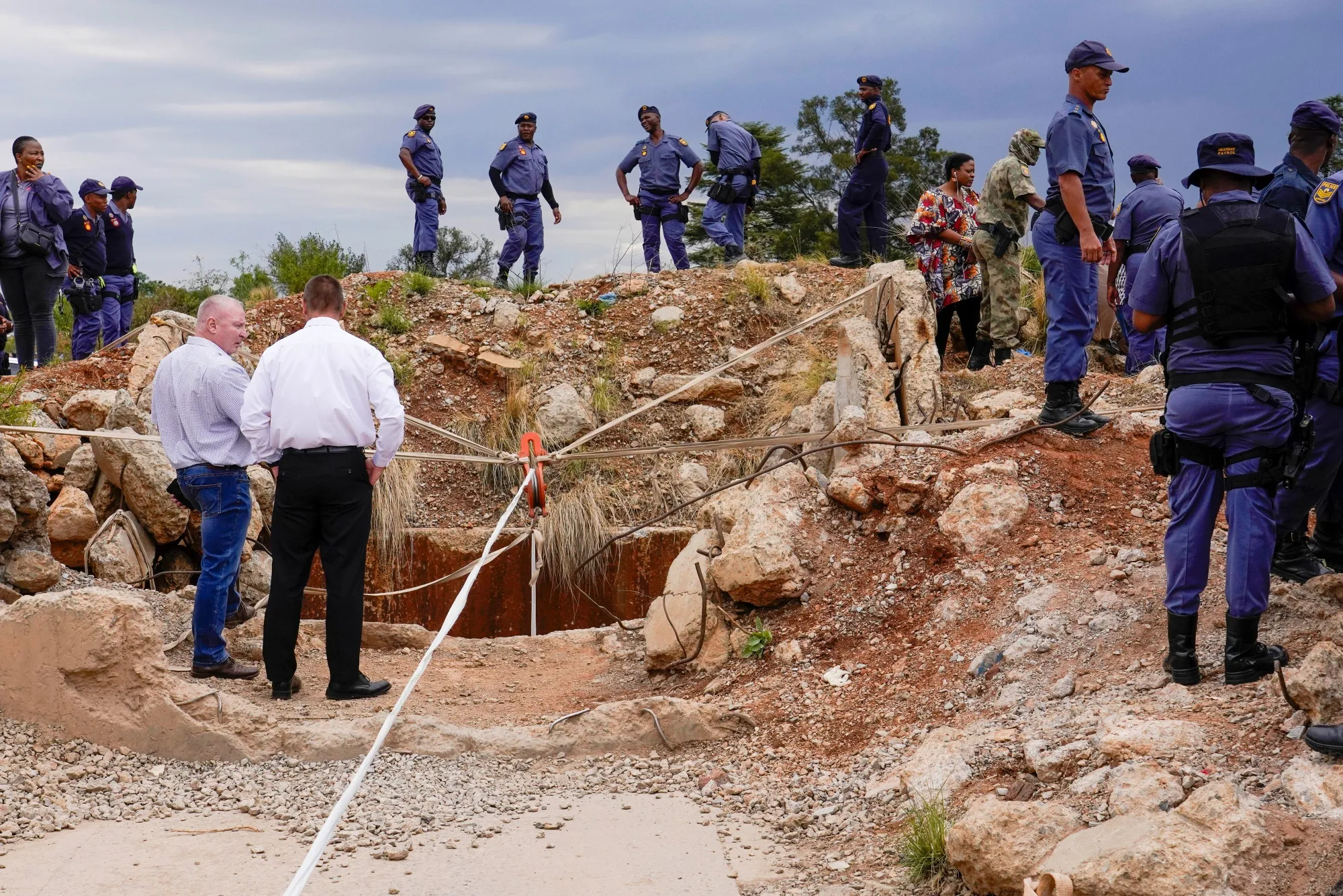 Police officers and private security personnel at the opening of a mineshaft in Stilfontein.