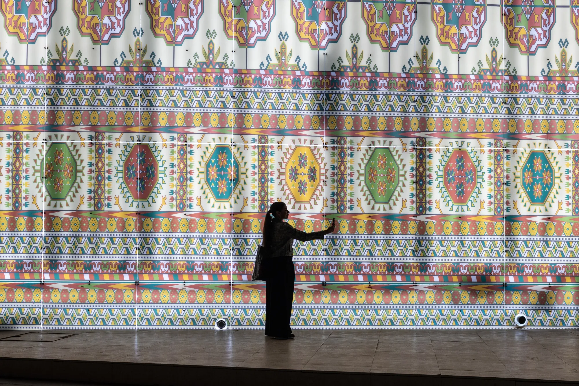 An attendee takes a selfie photograph against the Talhan Restaurant building in the Blue Zone of the COP28 climate conference at Expo City in Dubai, United Arab Emirates.