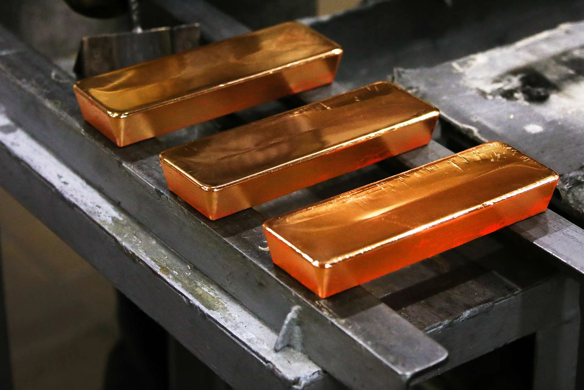 Three red hot gold ingots cool after being removed from casting molds by a worker in the foundry at the JSC Krastsvetmet non-ferrous metals plant in Krasnoyarsk, Russia, on Friday, March 3, 2017. Krastsvetmet refines and releases nonferrous metals.