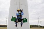 A technician climbs a wind turbine to inspect the rotor blades for damage in Brandenburg, Germany on May 27, 2020.