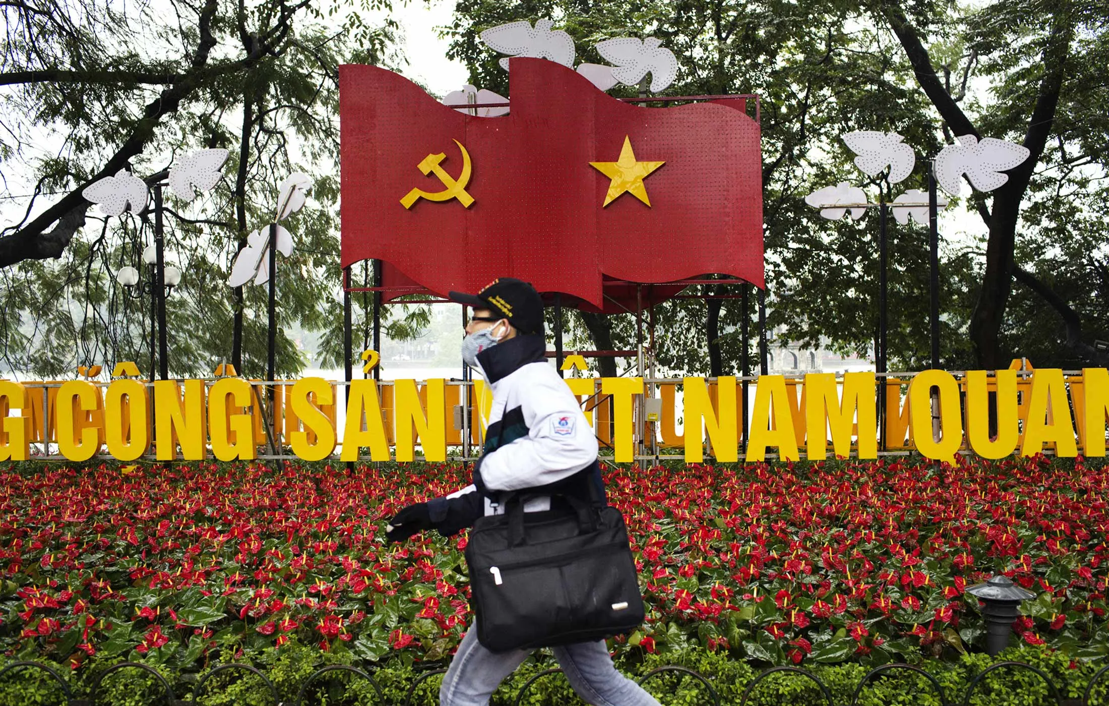 A pedestrian walks past a display advertising the 12th National Congress of the Communist Party of Vietnam in Hanoi, Vietnam, on Tuesday, Jan. 26, 2016.
