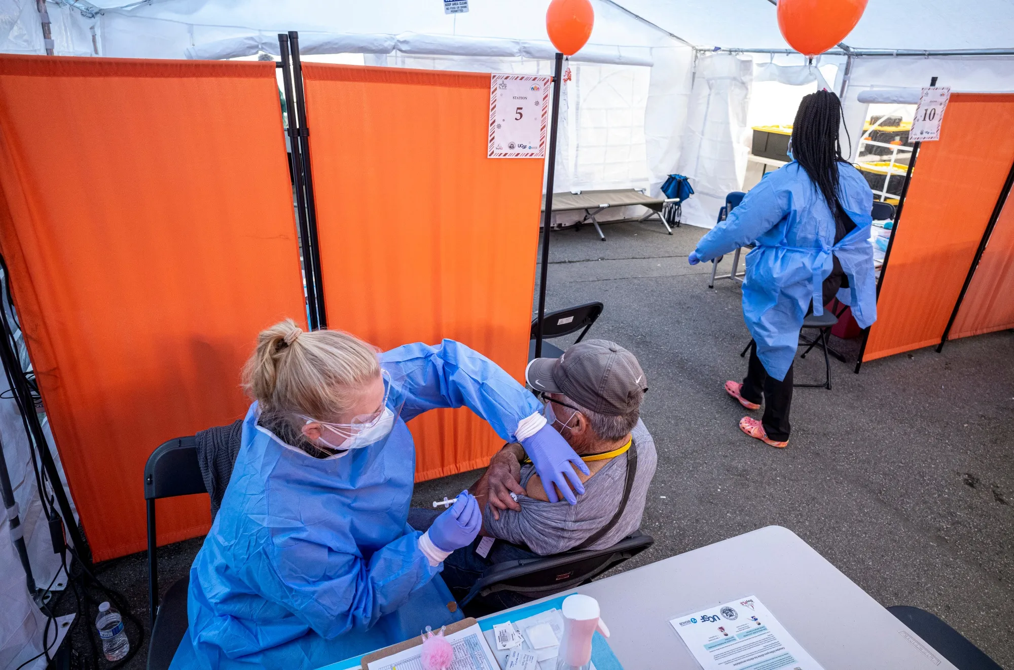 A healthcare worker administers a Pfizer-BioNTech Covid-19 vaccine at a vaccination site in San Francisco.