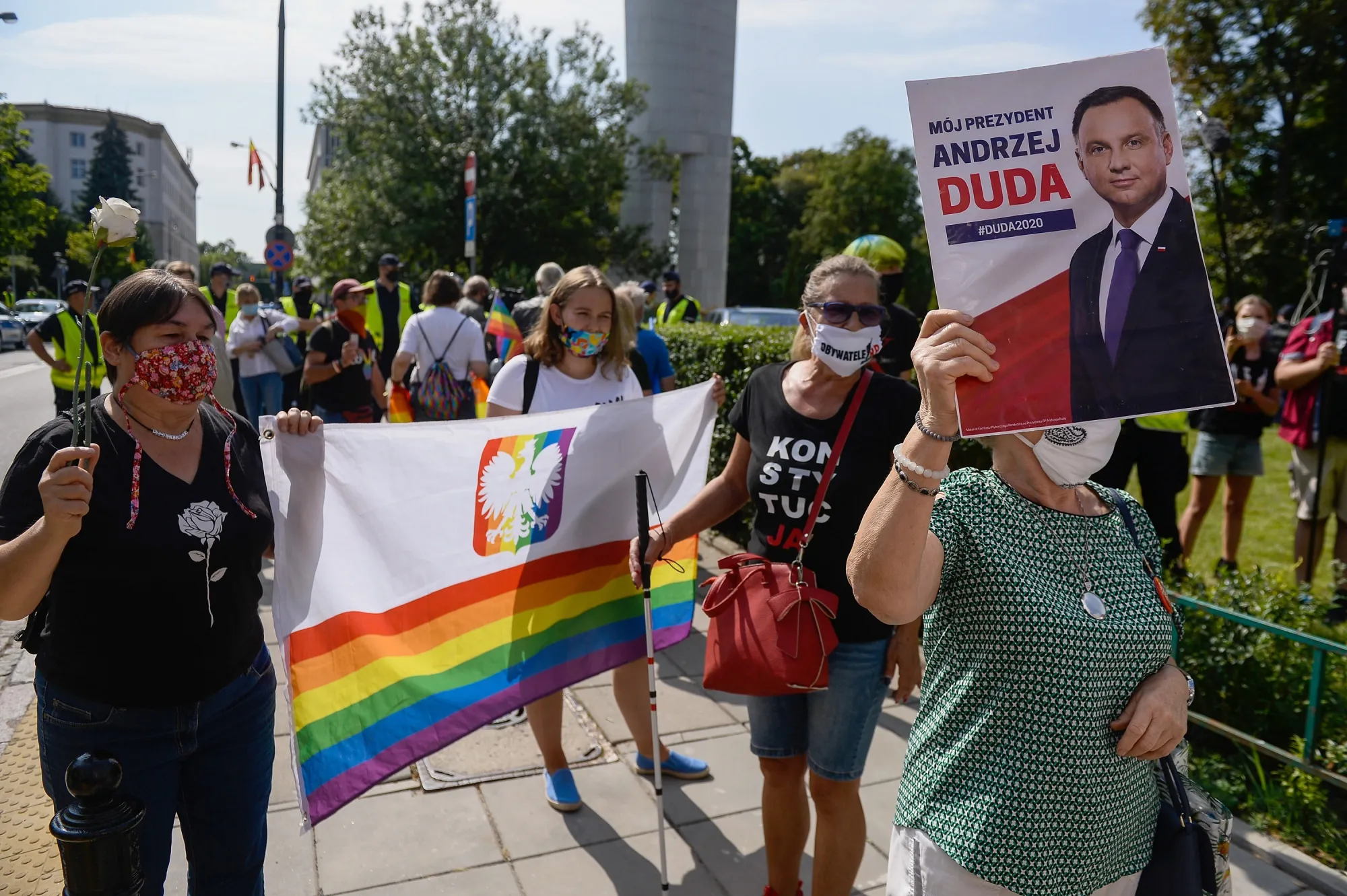 LGBT activists&nbsp;hold a rainbow flag with the Polish coat of arms as they protest outside parliament in Warsaw on Aug. 6.