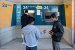 Customers wait on Monday to withdraw cash from a Bank of Cyprus ATM in Nicosia, Cyprus &#13;
&#13;
