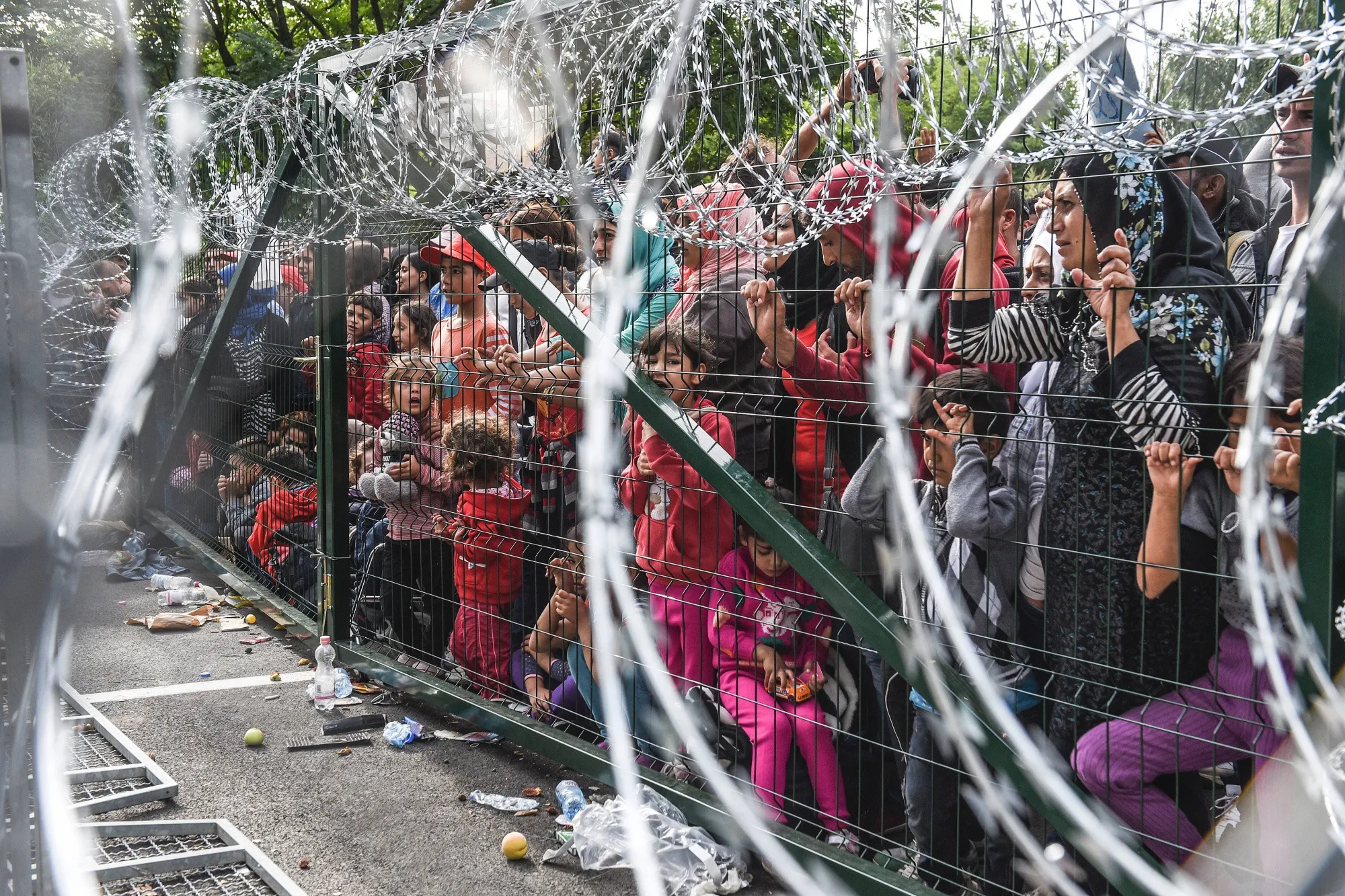 Refugees stand behind a fence at the Hungarian border&nbsp;near the town of Horgos in 2015.