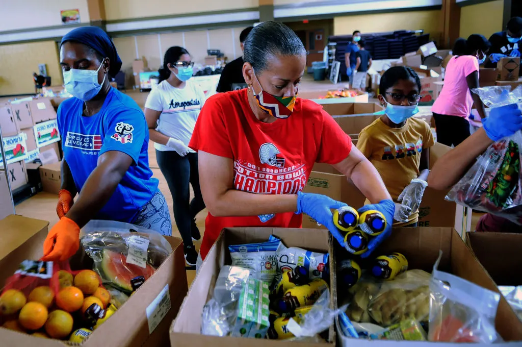APOPKA, FLORIDA, UNITED STATES - 2020/07/06: Volunteers prepare boxes of food from the Second Harvest Food Bank of Central Florida for distribution to the needy during a drive through food distribution event at City of Destiny church. The demand for food continues in the Orlando, Florida area due to the large numbers of service workers and others who have become unemployed due to the coronavirus pandemic. (Photo by Paul Hennessy/SOPA Images/LightRocket via Getty Images)