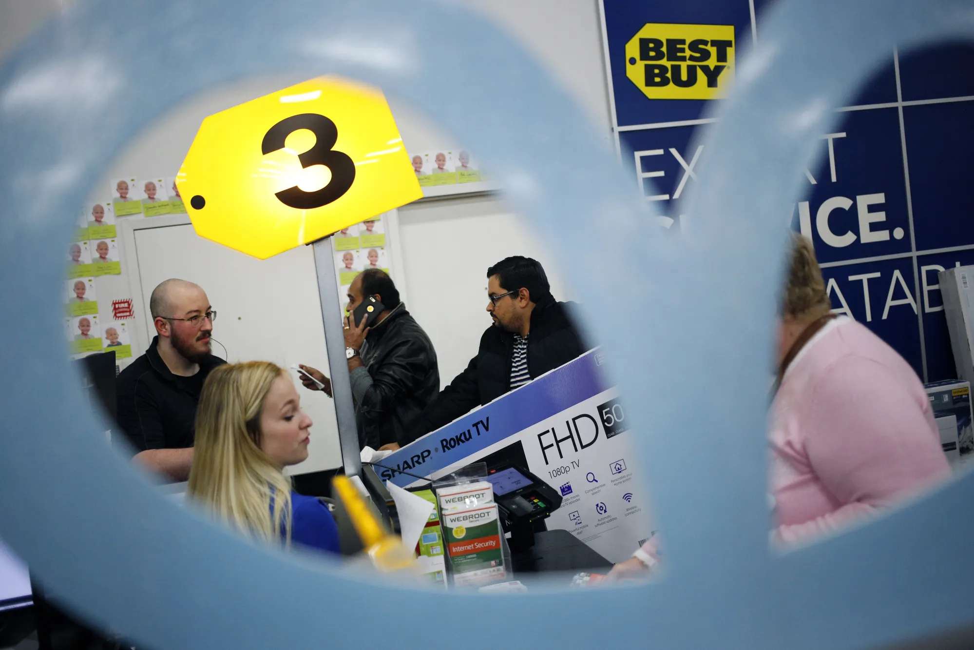 A cashier, left, serves customers at a check out counter inside a Best Buy Co. store in Louisville, Kentucky, U.S.