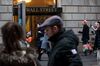 Pedestrians walk along Wall Street near the New York Stock Exchange (NYSE) in New York, U.S..