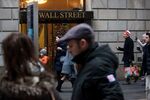 Pedestrians walk along Wall Street near the New York Stock Exchange (NYSE) in New York, U.S..