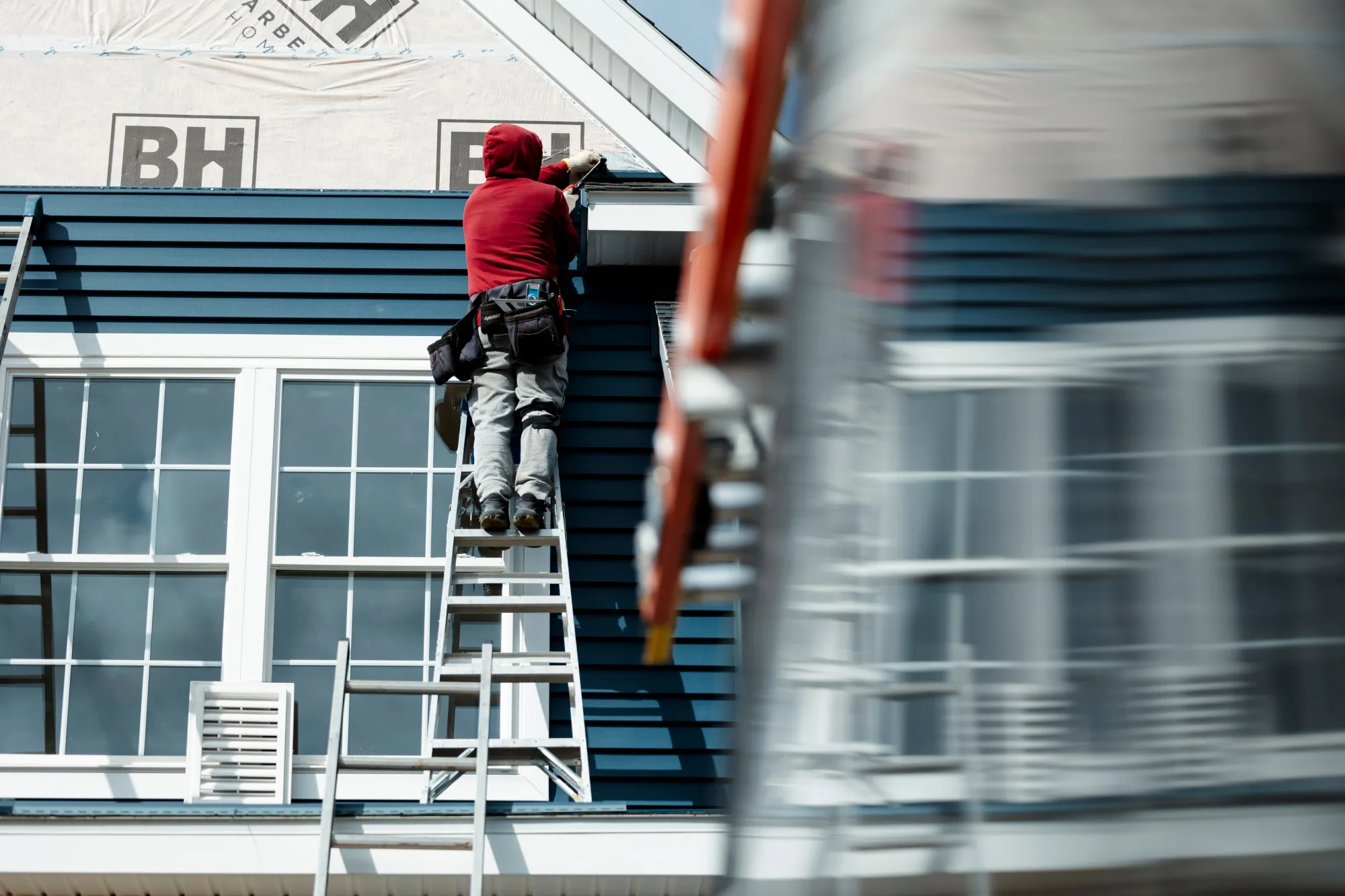 A worker installs siding on a home under construction in Loudonville, New York, earlier this month. US hiring and household purchases have been accelerating, new data shows.