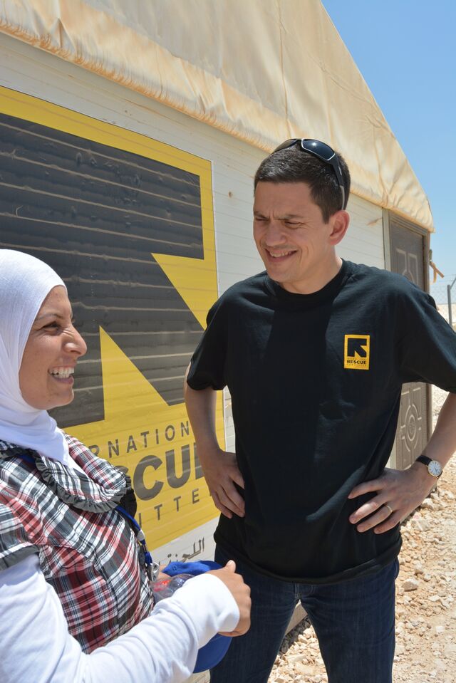 Miliband speaks with an IRC staff member at the Zaatari refugee camp in Jordan.