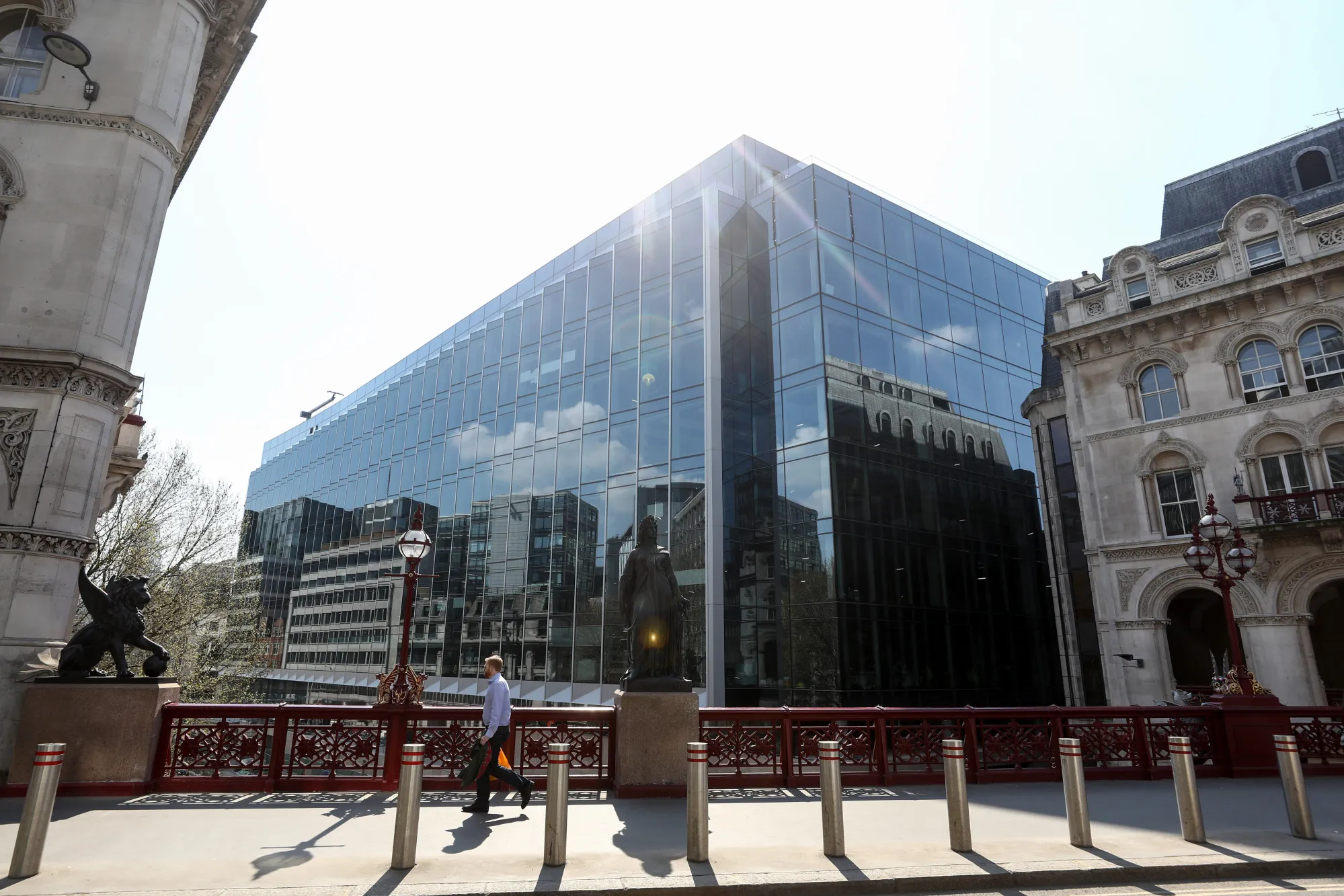 A pedestrian crosses a bridge in view of the European headquarters of Goldman Sachs&nbsp;in London.