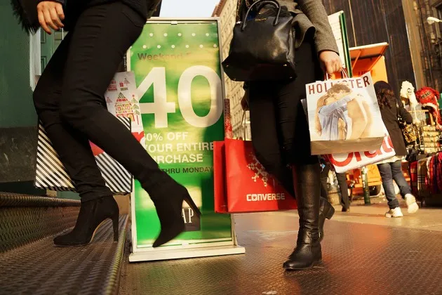People carry shopping bags along Broadway in New York on Dec. 2, 2013